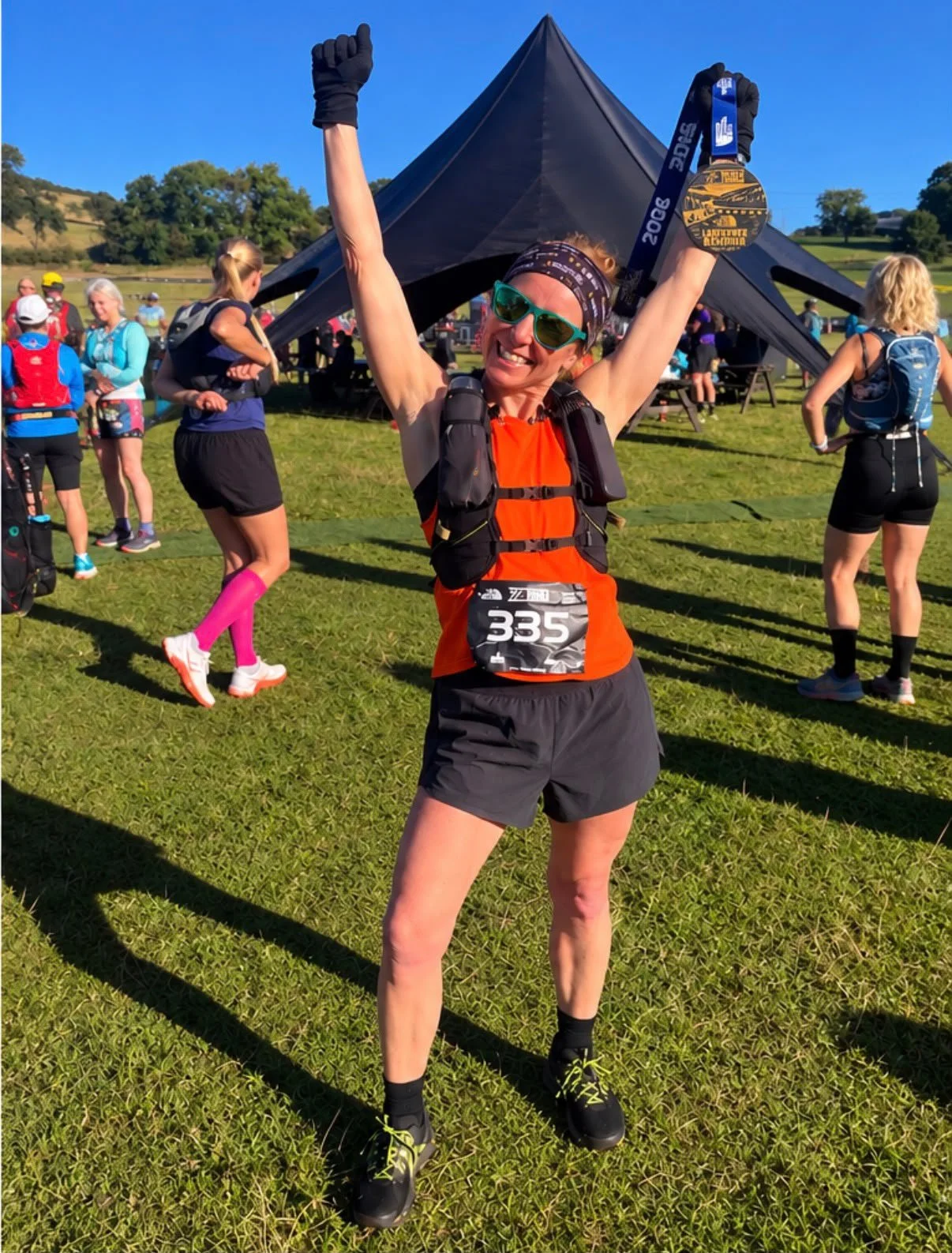 Claire from Beyond Running celebrating with her medal after the Ladybower Trail Half Marathon