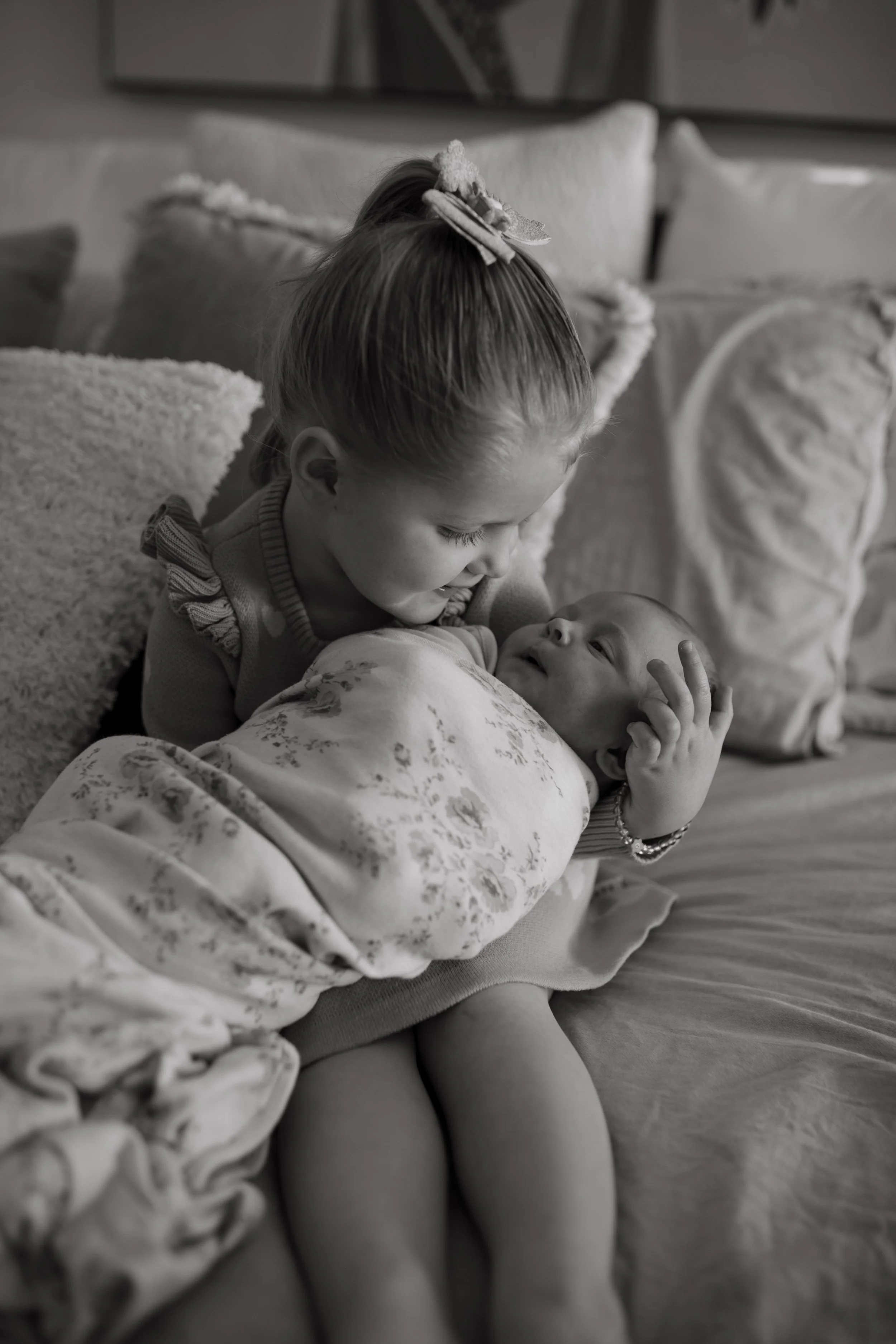 indoor-newborn-shoot-big-sister-holding-baby-brother.jpg