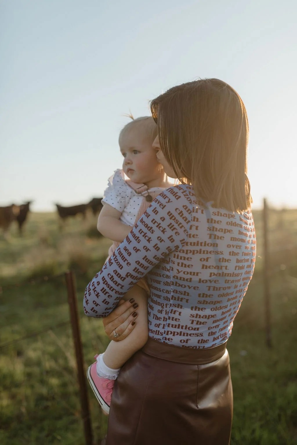 Mum kissing her baby at sunset during a family photoshoot on their family farm, captured with warmth and authenticity by Jade Jones Photography.