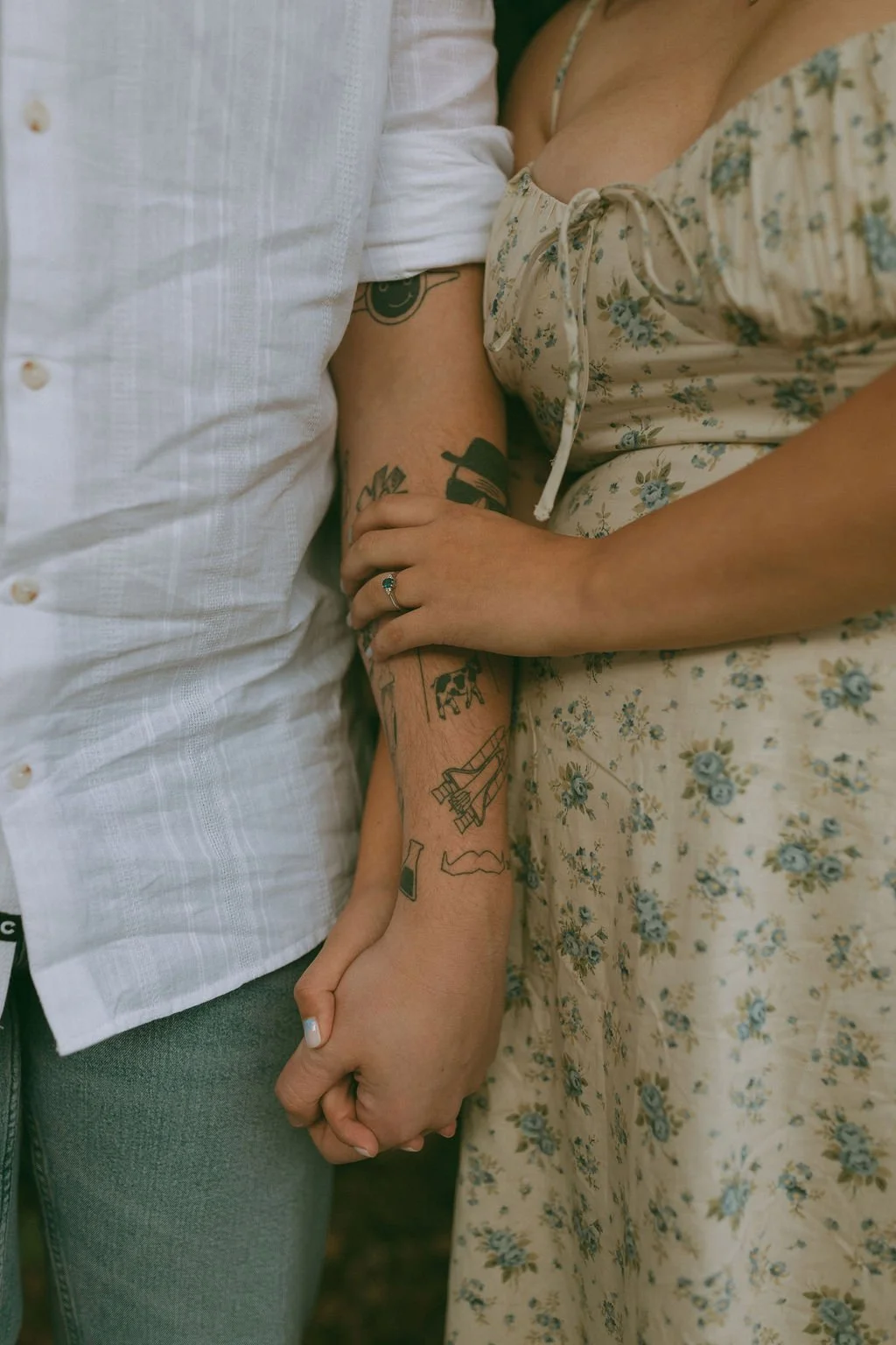 Close-up of an engaged couple holding hands and showcasing her engagement ring during a romantic engagement photoshoot by Jade Jones Photography.