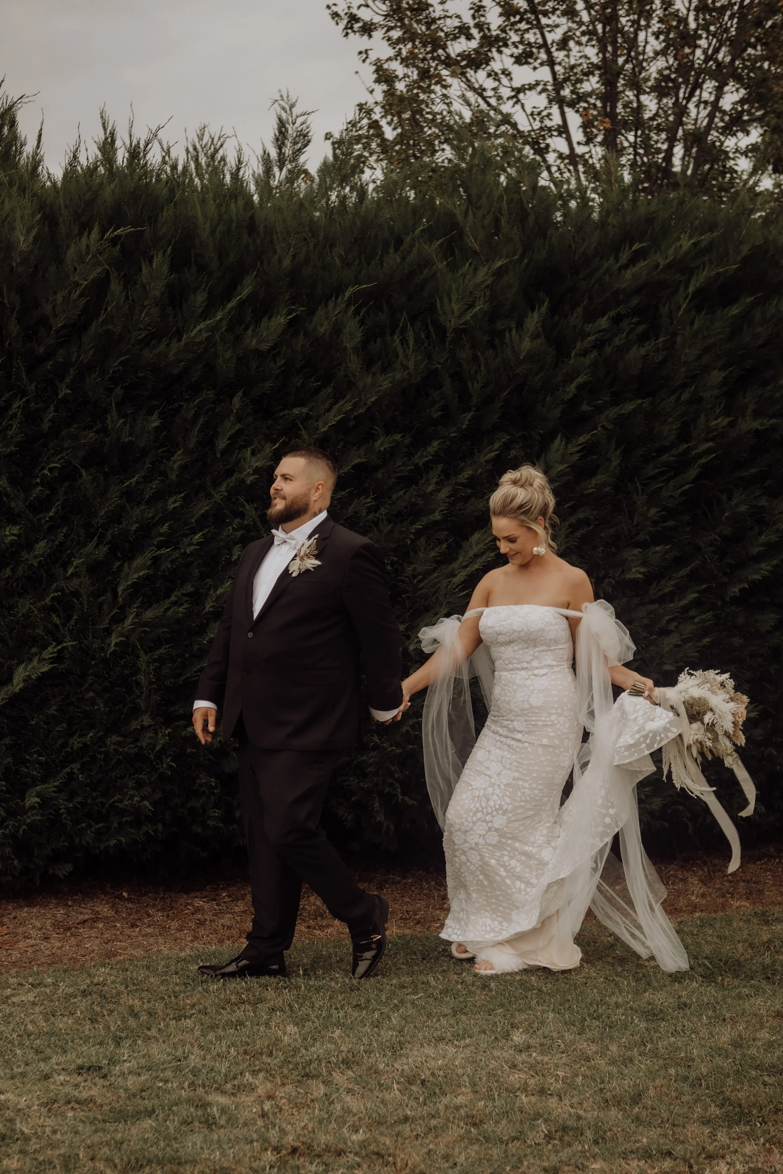 bride-and-groom-walking-hand-in-hand-outdoor-wedding.jpg