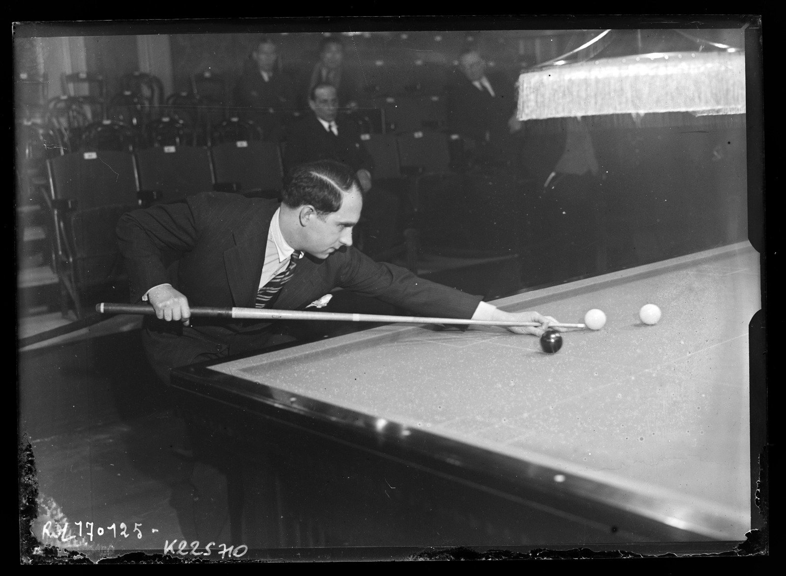 Roger Conti joueur de billard en action dans une salle du boulevard des Capucines à Paris, figure du billard français.