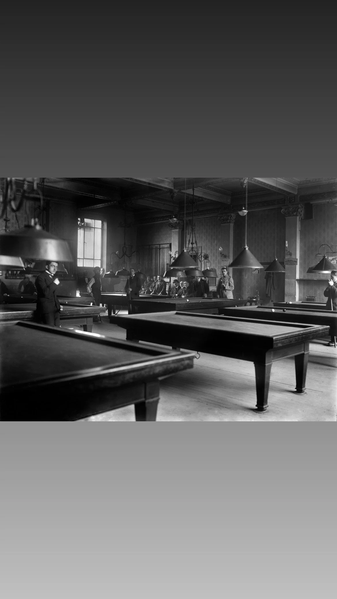 Joueurs amateurs de billard à l’étage dédié aux débutants dans une salle du boulevard des Capucines à Paris.