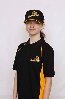 Young girl wearing a black baseball cap and a black polo shirt with yellow accents, posing against a neutral background.
