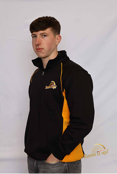 Young man with short brown hair wearing a black and yellow jacket, standing against a white background.