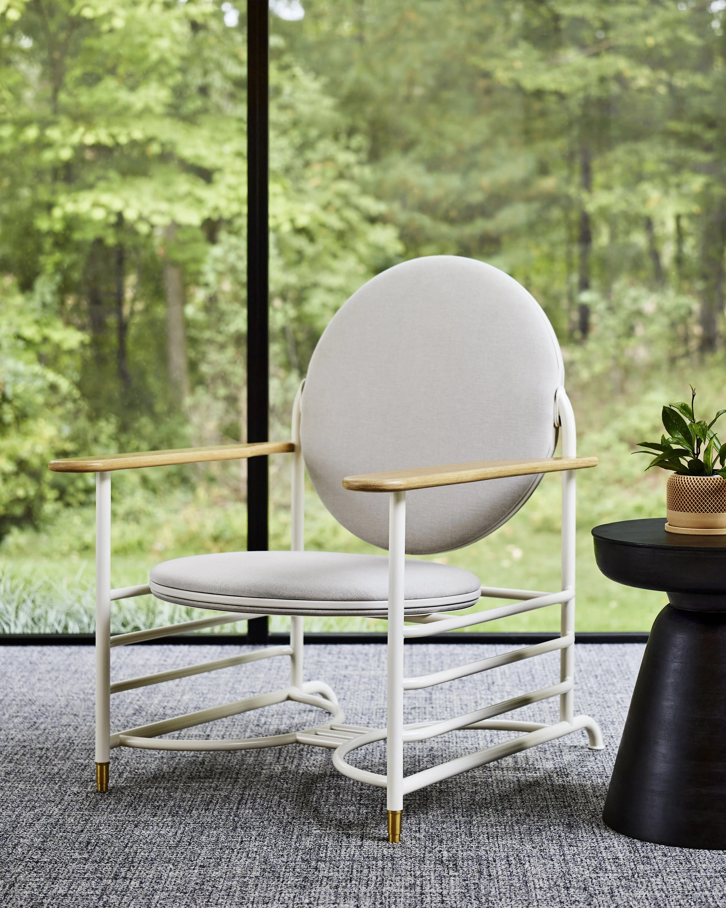 Modern white chair with light wood armrests and a round cushioned seat.