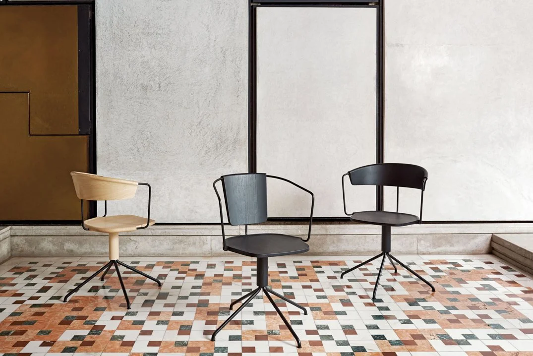 Three modern chairs with swivel bases on patterned tile floor.