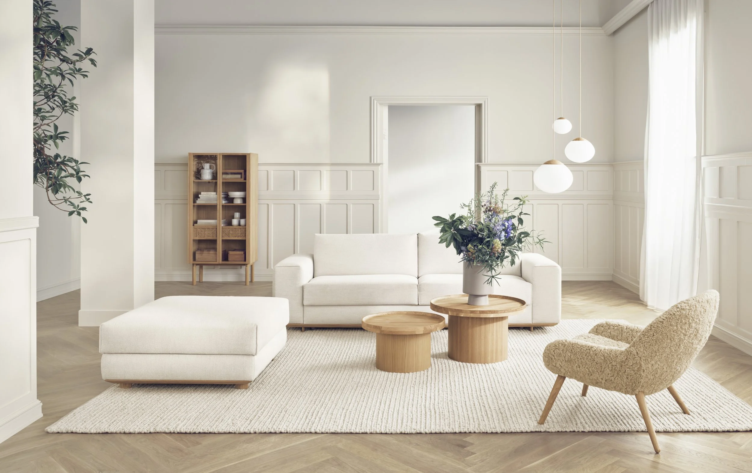 Lounge area featuring Bolia furniture, including a beige sofa, beige armchair, two wooden coffee tables, and a wooden cabinet.