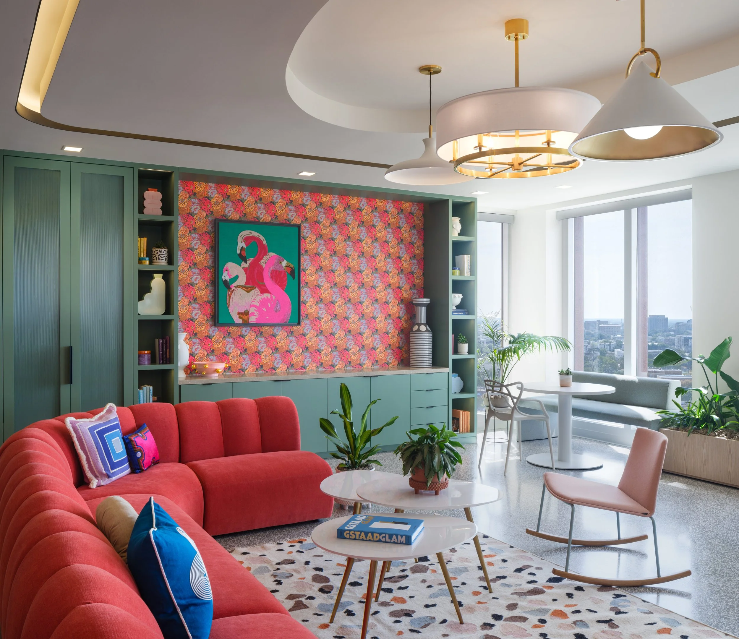 Colorful modern lobby area featuring a West Elm Work sectional sofa and a pink rocking chair.
