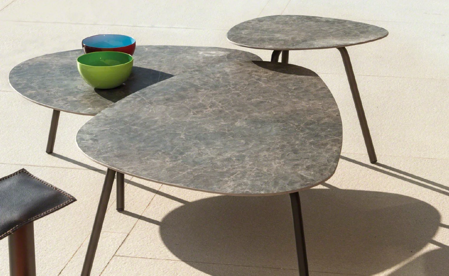 Three gray marble stacking tables of varying sizes with black legs.
