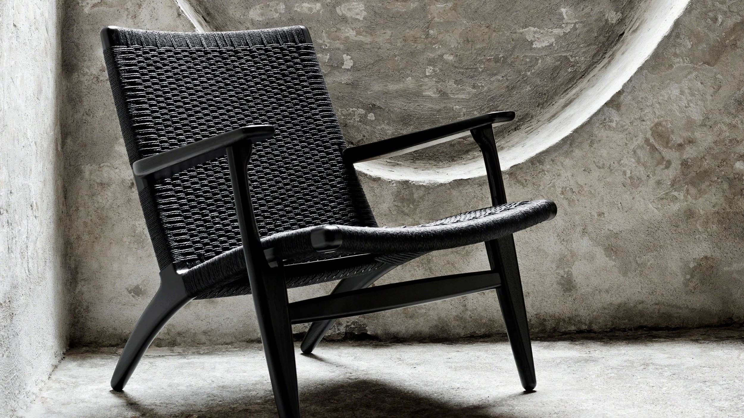 Modern black woven armchair from Carl Hansen & Søn with wooden legs.