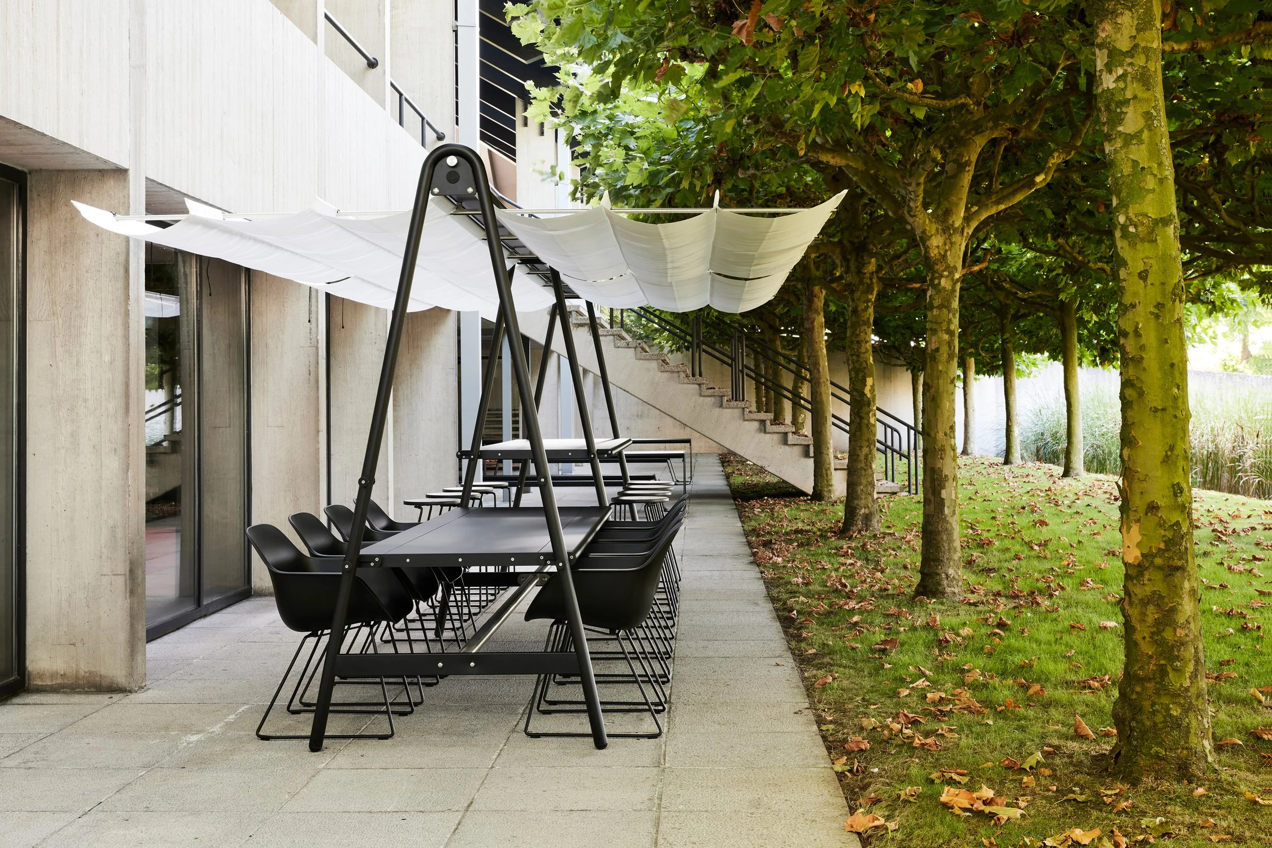 Outdoor patio area featuring black chairs and a black table under a white shade cloth.