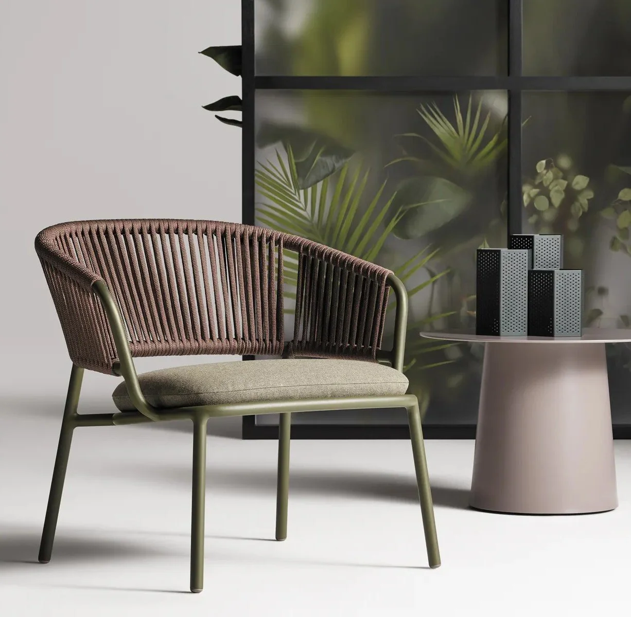 Modern indoor setting with a metallic, woven armchair with a fabric cushion, beside a round white table from Blu Dot.