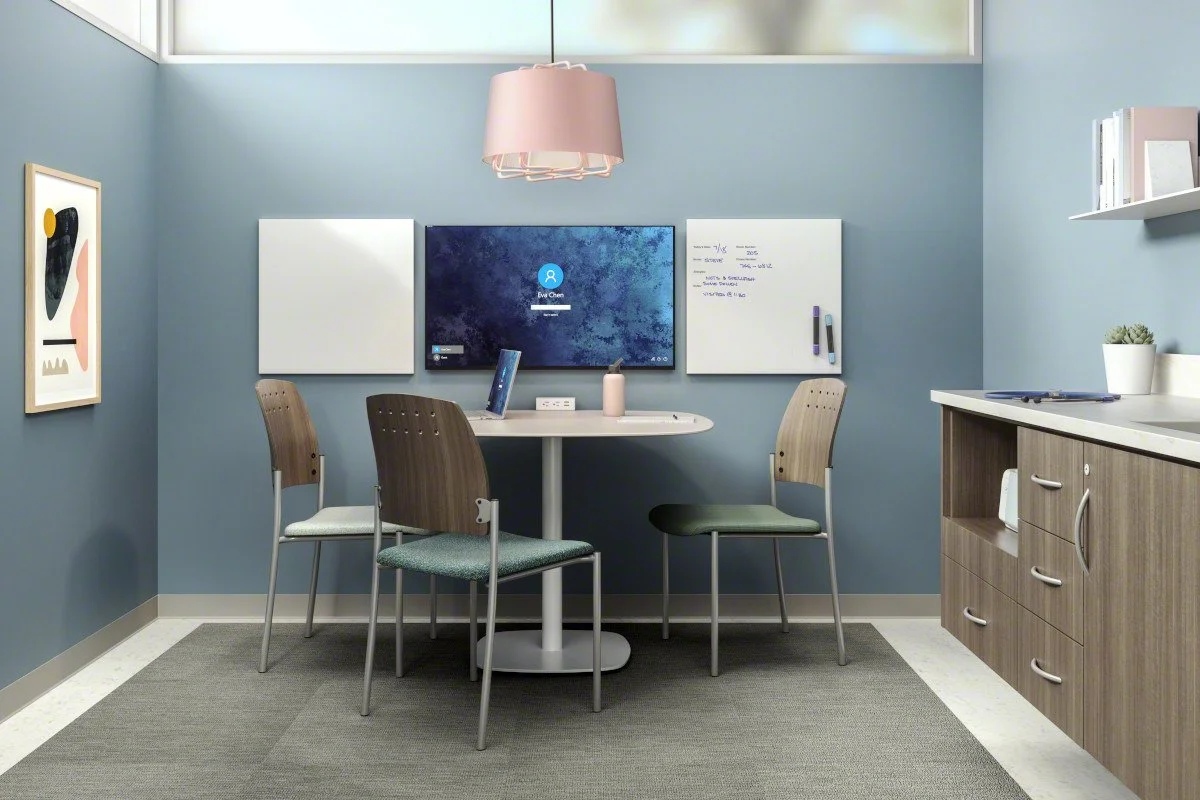Office meeting room featuring a round table with four chairs and casework by Steelcase Health.