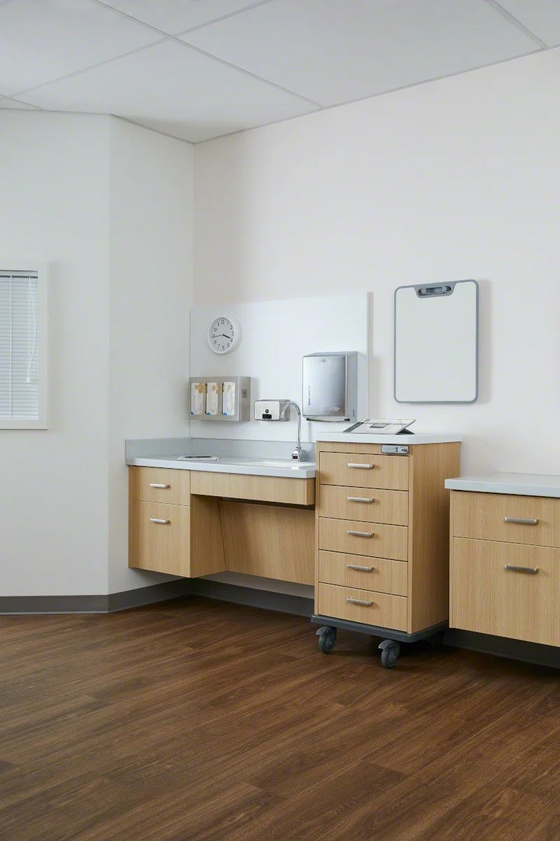 Hospital or clinic room featuring wooden casework by Steelcase Health, equipped with essential healthcare furnishings and equipment.