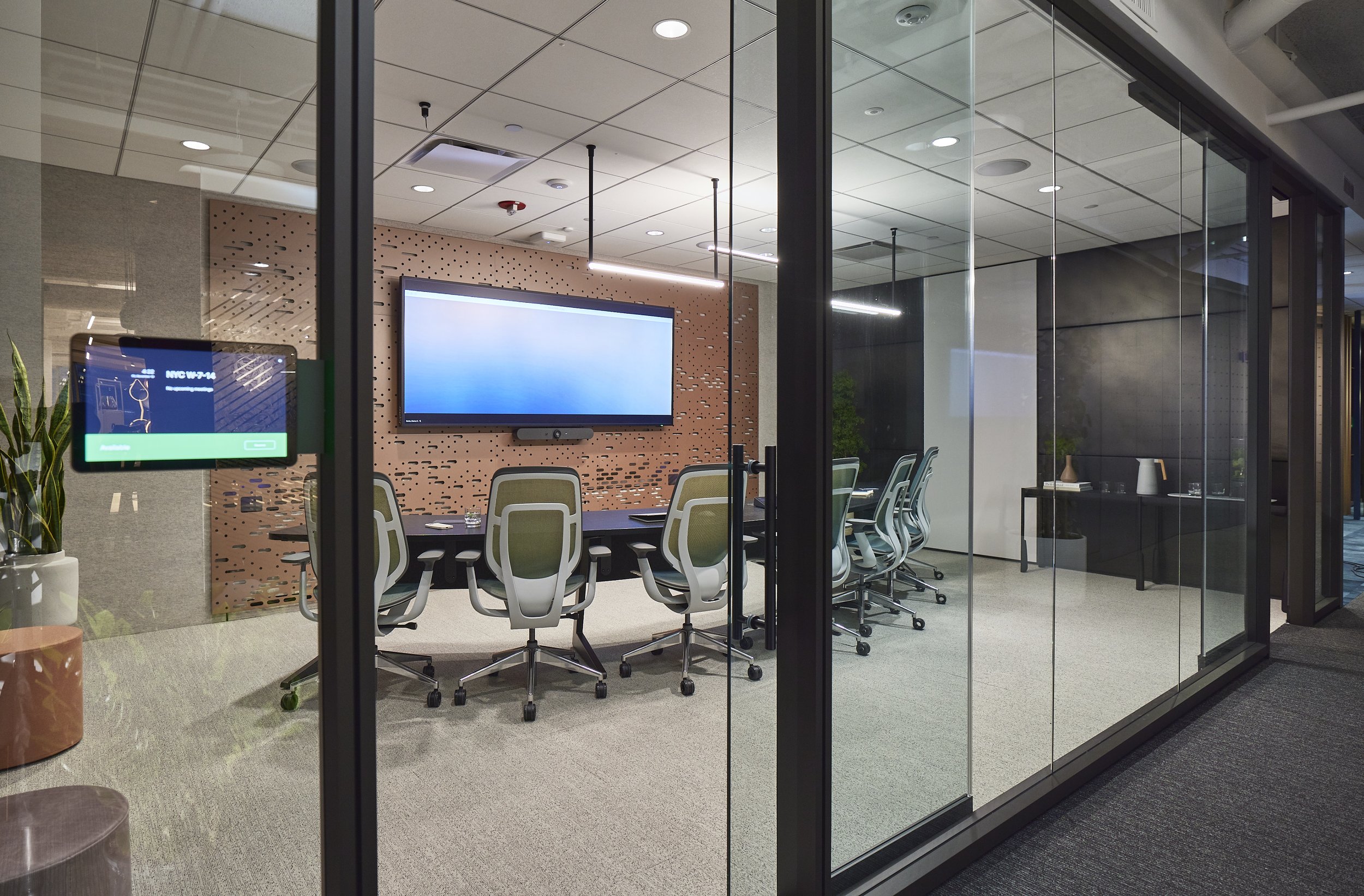 Modern conference room equipped with Microsoft Teams Rooms technology, featuring a large screen for video meetings and integrated room scheduling.