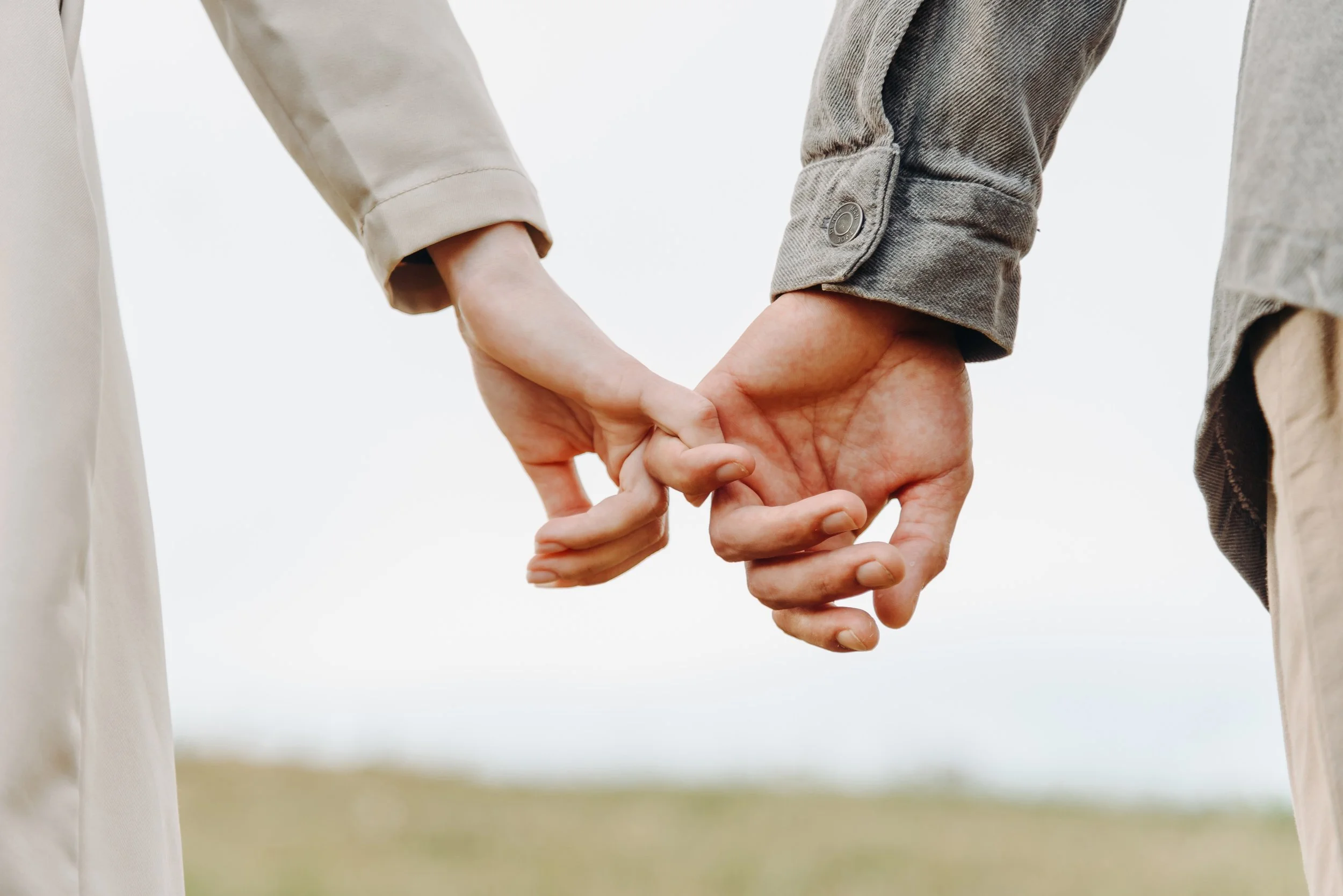 Zwei Menschen halten sich an den Fingern. Bewusst in Beziehung wachsen und Verbindung vertiefen