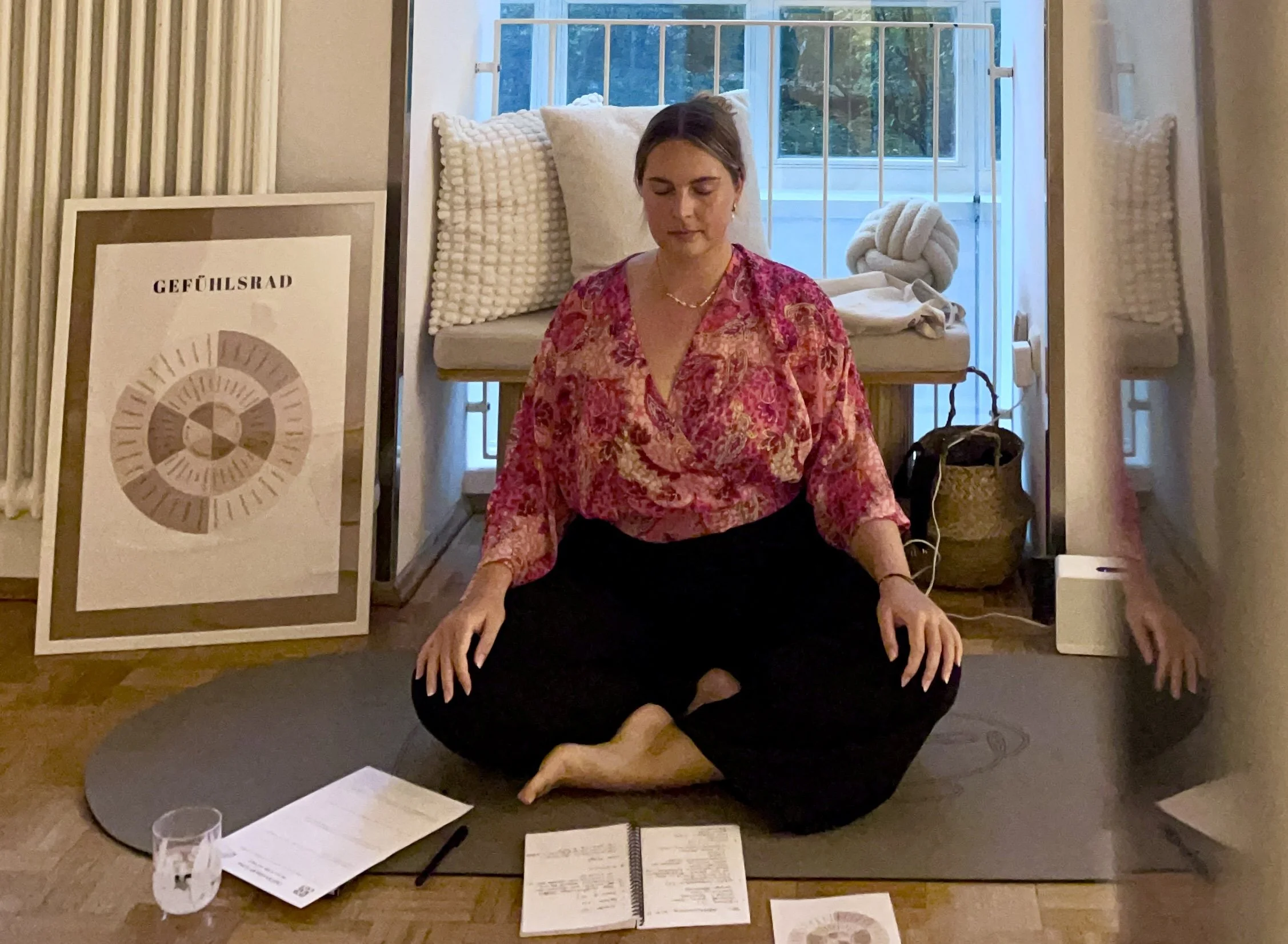 Frau sitzt auf Yogamatte beim Meditieren