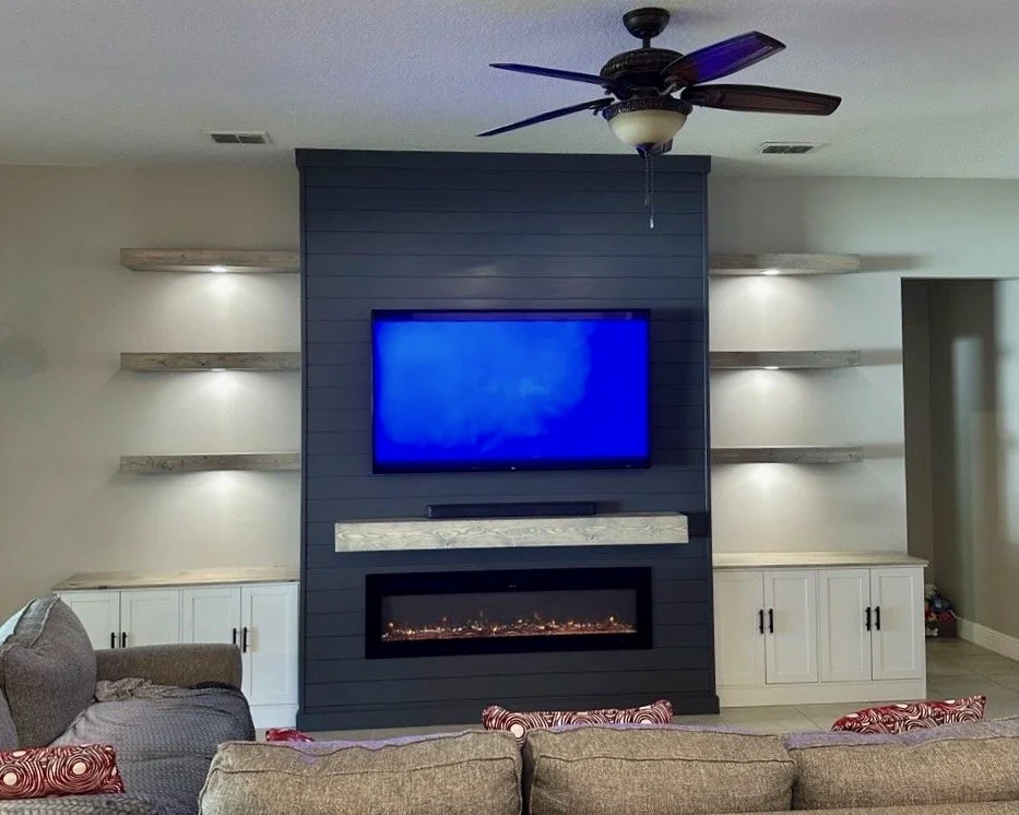 floating wood shelves with integrated LED lighting on custom media wall