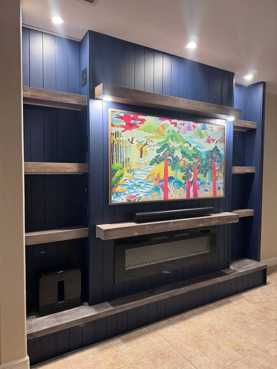 Detailed view of a Dallas media wall featuring deep navy vertical shiplap, stained wood shelves, a substantial mantel, and an integrated electric fireplace.