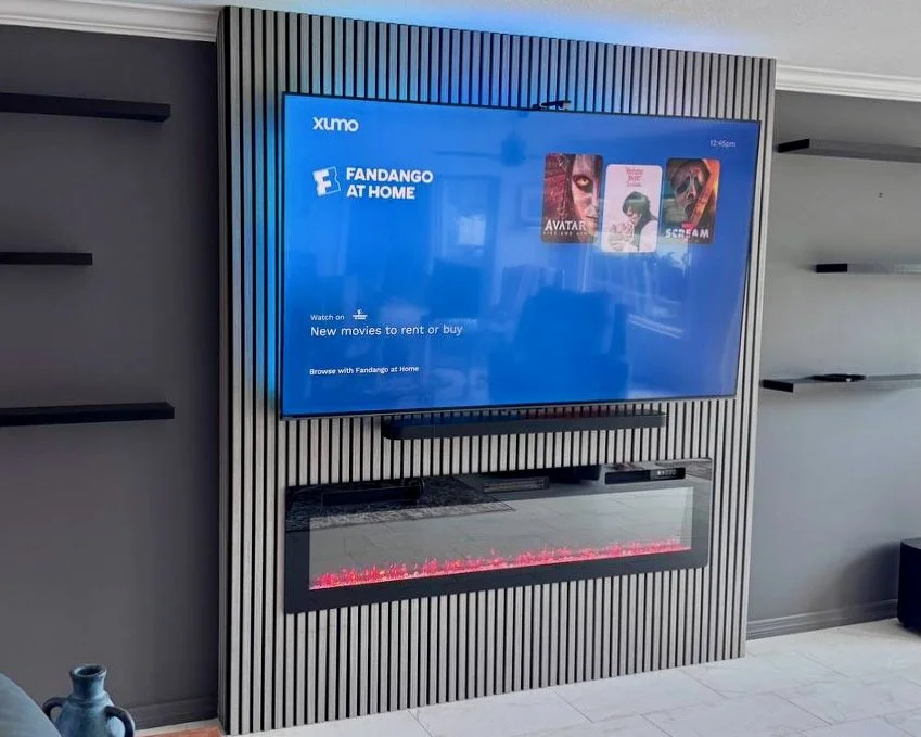 close up of slat panel tv wall with fireplace and media shelf