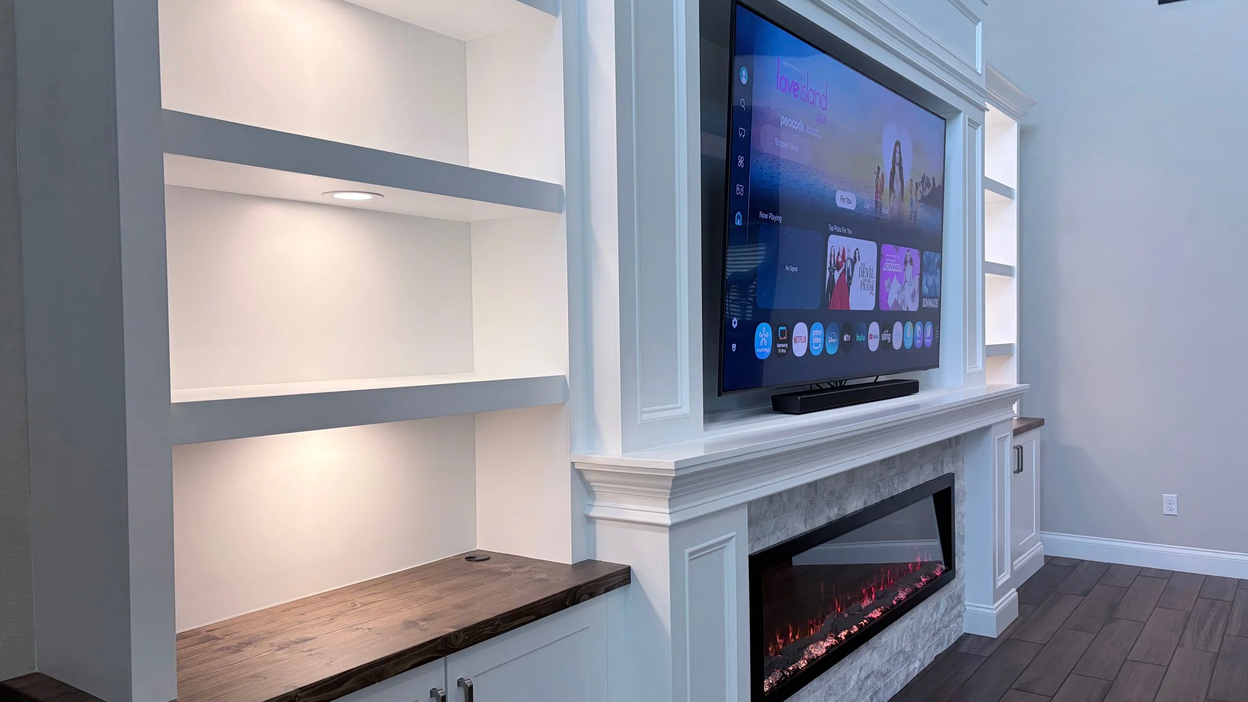 Close-up of custom built-in shelving with recessed LED lighting, wood countertop and architectural trim