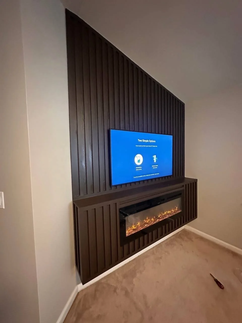 Side perspective highlighting the depth and dimensionality of the media wall design, with evenly spaced vertical slats and a seamlessly integrated electric fireplace.