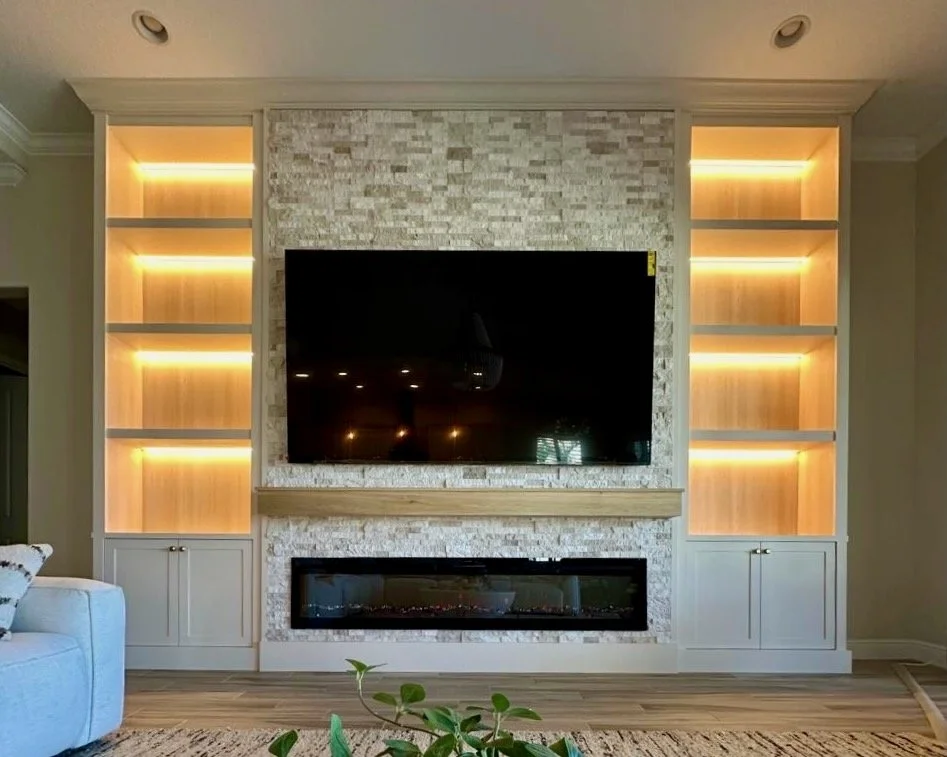 Grand built-in media wall with stone center, LED niches, large TV and fireplace in Apollo Beach Florida