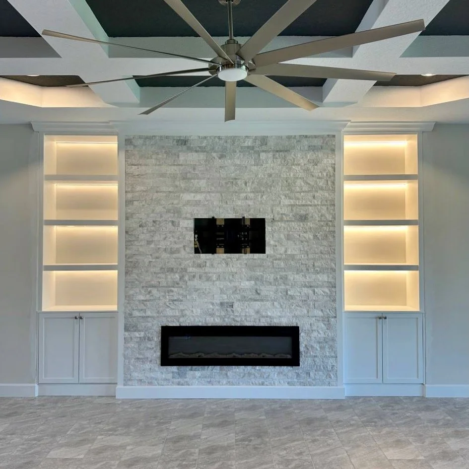 Custom fireplace media wall with illuminated shelves and cabinets