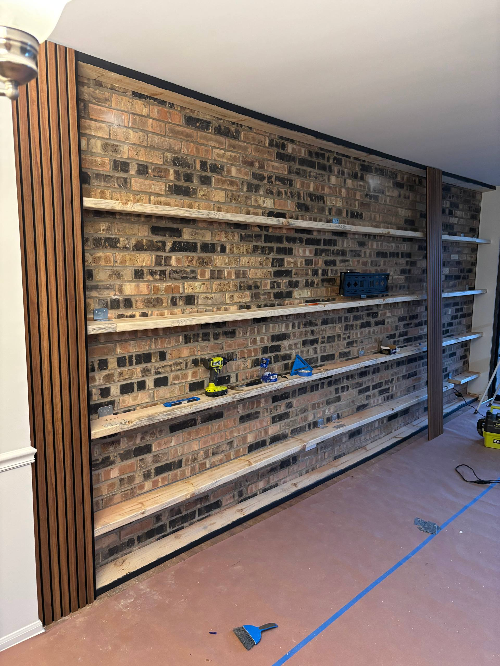 Media wall installation process with shelves and brick wall background