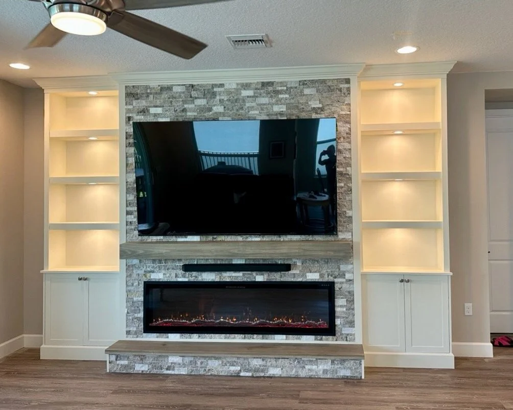 Stone built-in entertainment center with custom cabinets and electric fireplace on Florida Space Coast