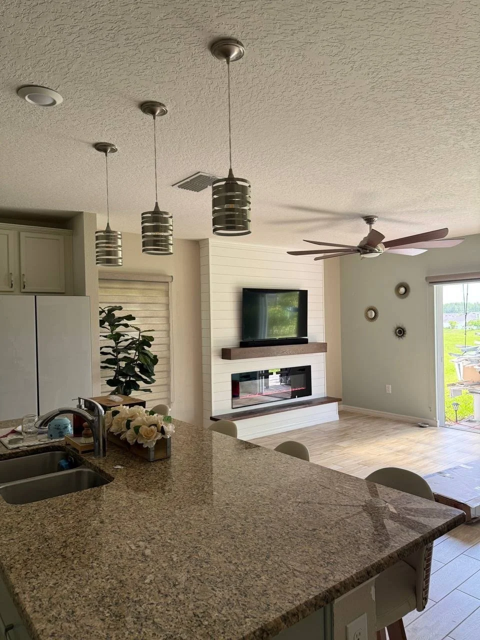 A wide-angle perspective showing how the white shiplap fireplace media wall integrates seamlessly into the open-plan layout of the Winter Park residence.