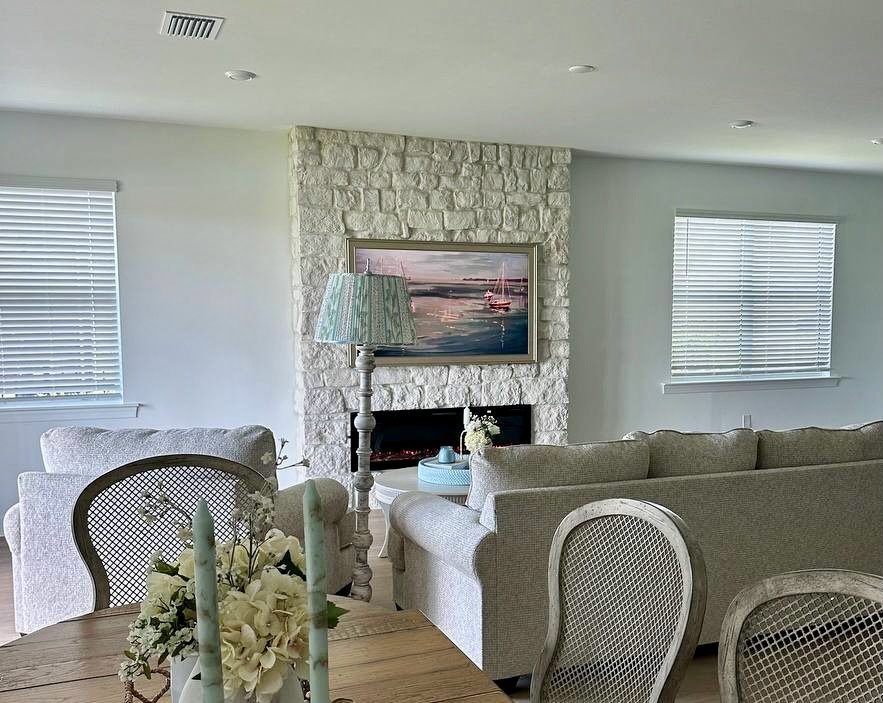 Wide living and dining room view showing a white stone electric fireplace feature wall in a Punta Gorda, Florida home.