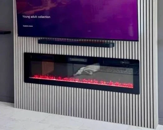A modern electric fireplace beneath a mounted flat-screen TV in a contemporary room.