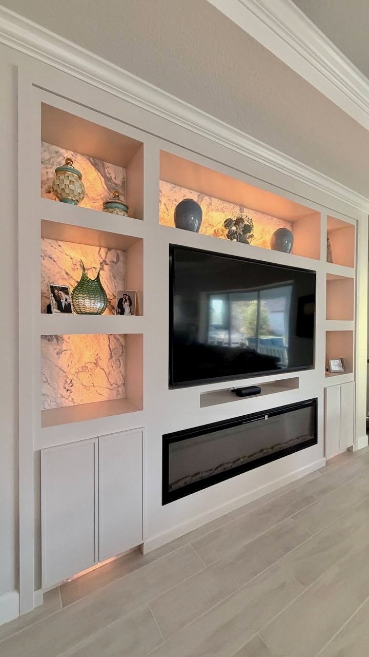 Close view of custom display niches with decorative panels illuminated from behind in a Tampa media wall project.