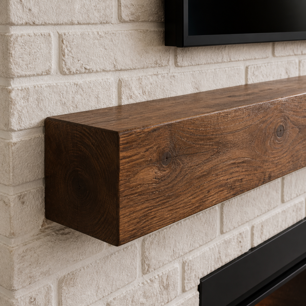 Natural walnut fireplace mantel with visible end grain installed against whitewashed running-bond brick