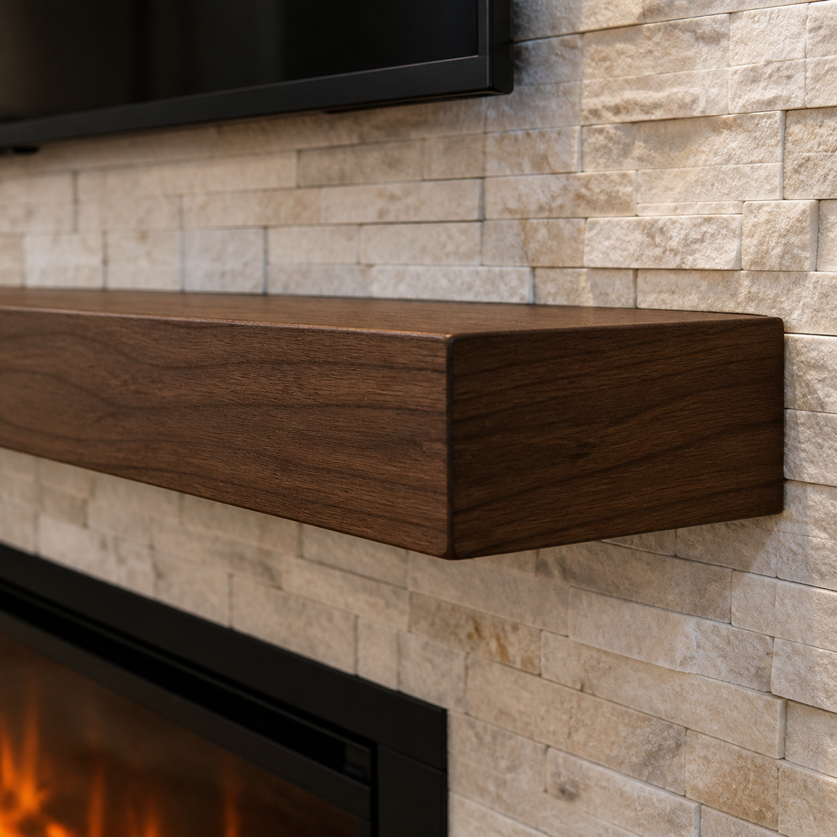 Close-up of a custom dark walnut floating mantel installed against light ledger stone veneer