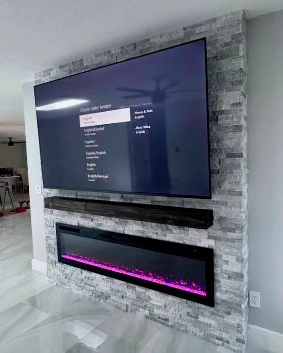 Side angle of stone TV wall with fireplace in Tampa Bay home