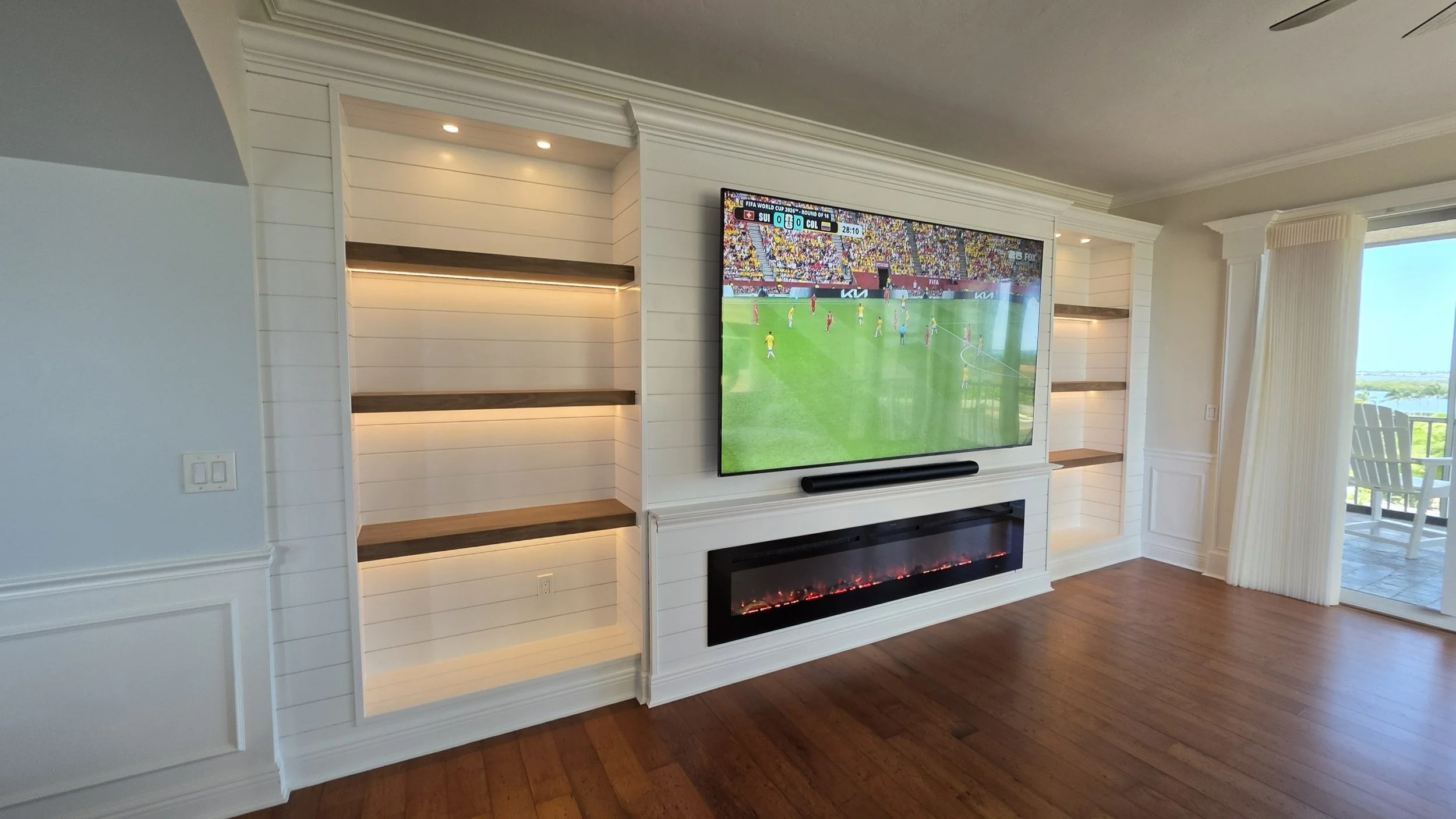 Custom shiplap fireplace media wall in Cape Coral with built-in shelving, LED lighting, crown molding and linear electric fireplace