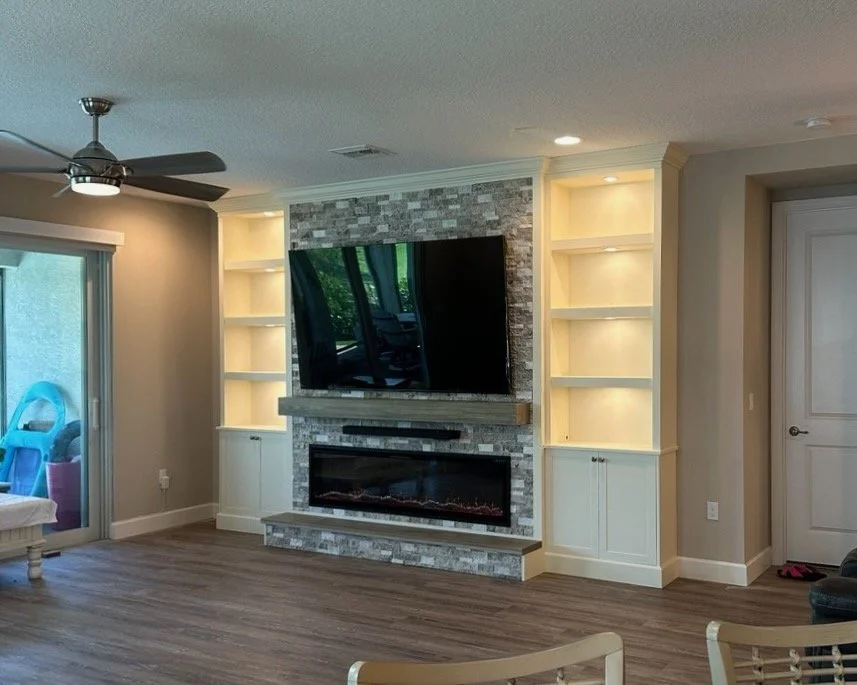 Coastal style TV media wall with illuminated shelving and electric fireplace in Cocoa Beach Florida