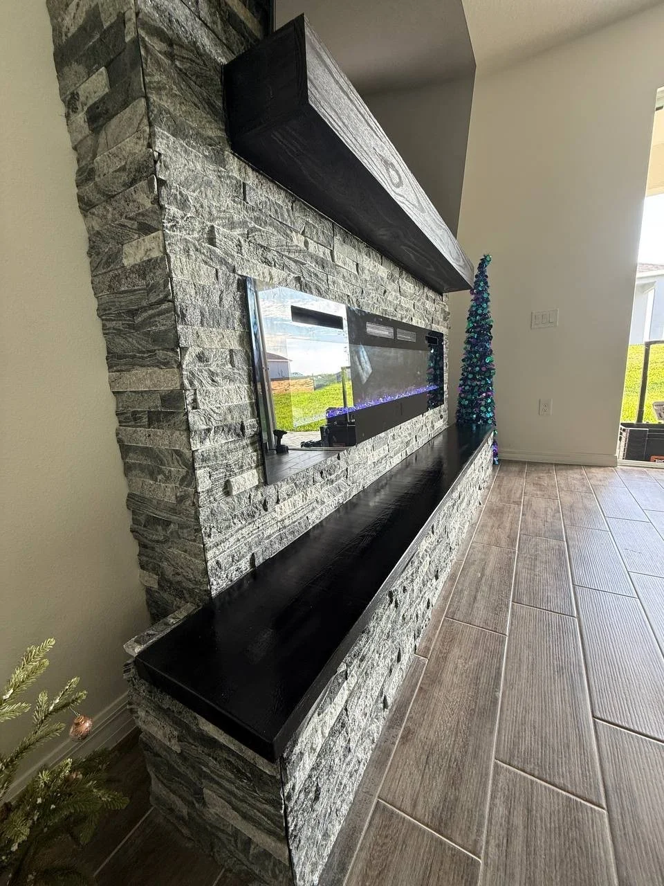 Palm Bay_fireplace buildout stone with tv.jpeg