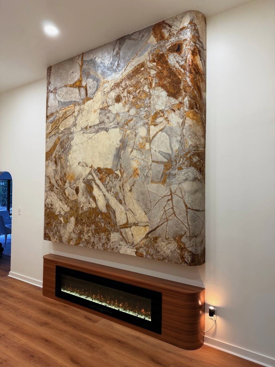 Decorative marble-effect media wall with floating fireplace cabinet and architectural wall finish in Houston Texas
