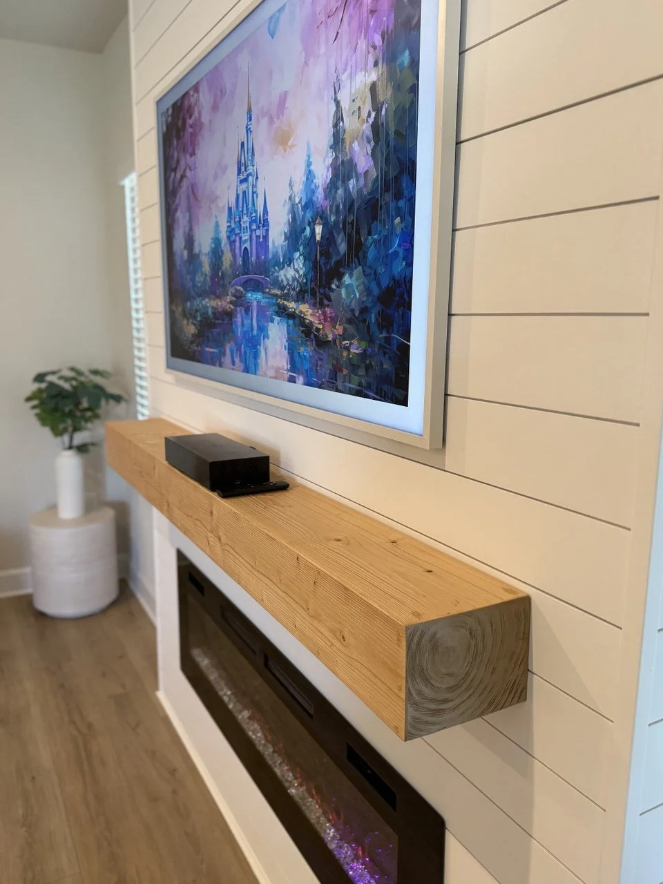 solid wood mantel beam installed above electric fireplace on a shiplap media wall