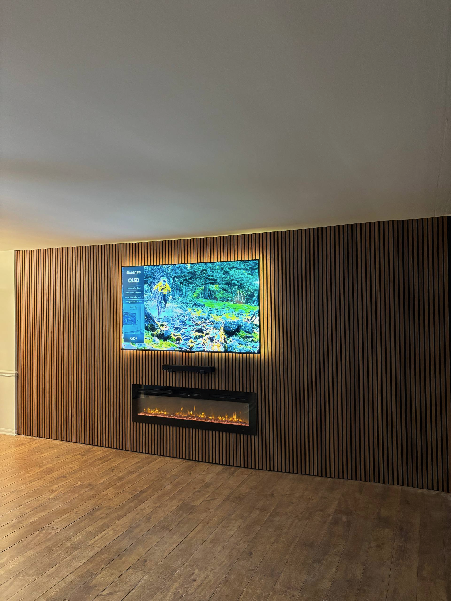 Wide view of wood slat TV wall with fireplace in Orlando home