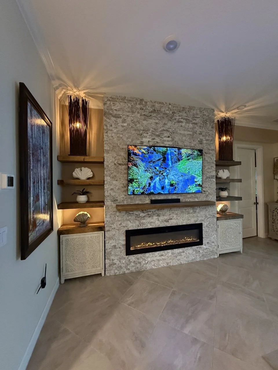 ledger stone fireplace media wall with floating shelves and built in cabinets in Punta Gorda Florida living room