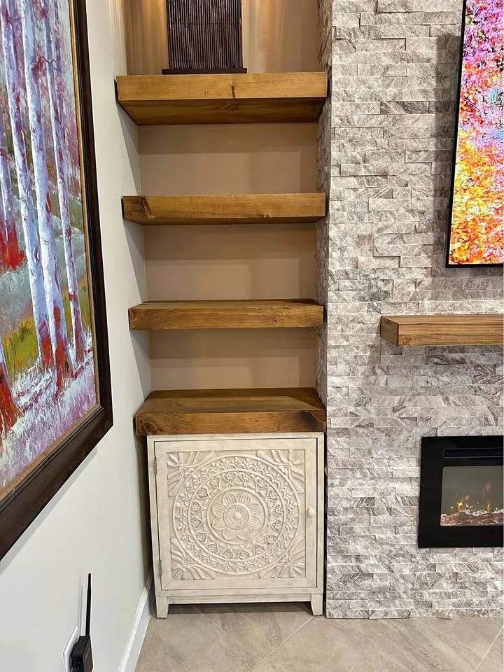 custom storage cabinet and floating shelves integrated into stone fireplace media wall design