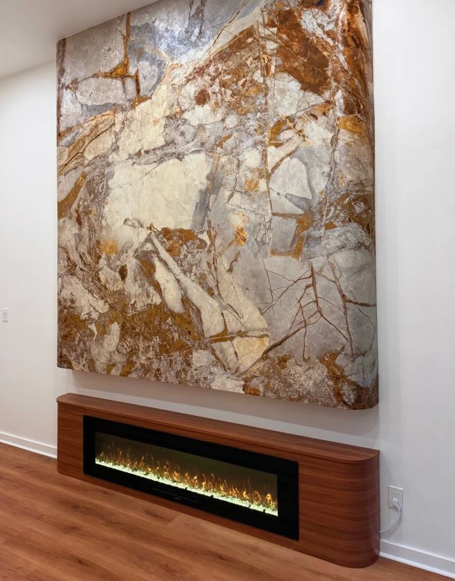 Custom curved marble-effect fireplace wall with floating wood base and modern linear fireplace