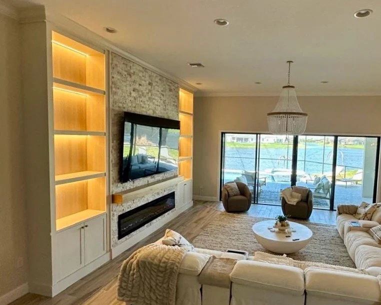Wide living room view with custom media wall, LED shelves, stone finish and waterfront home in Apollo Beach