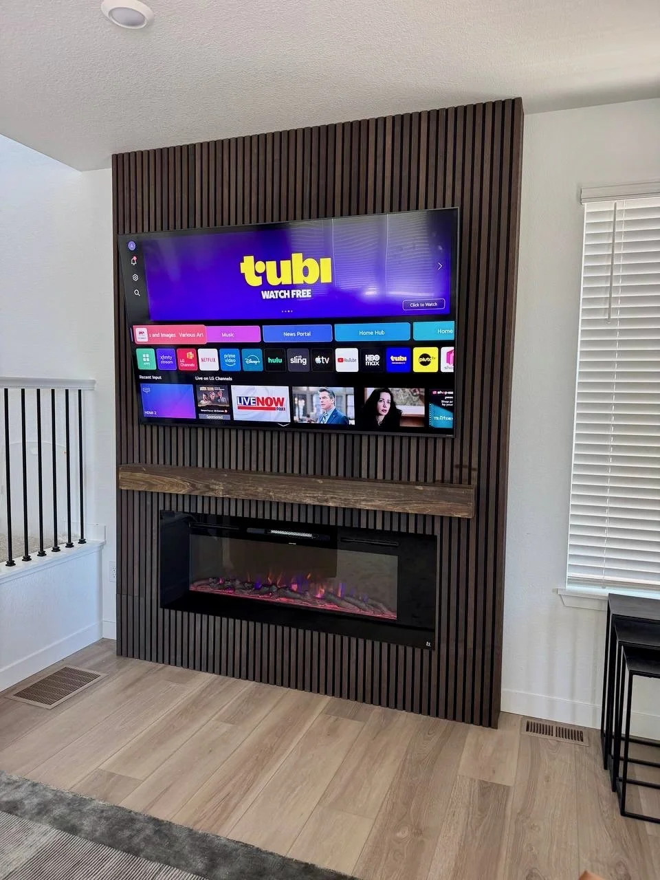 modern wood slat fireplace media wall with mounted TV and electric fireplace in Stuart Florida living room