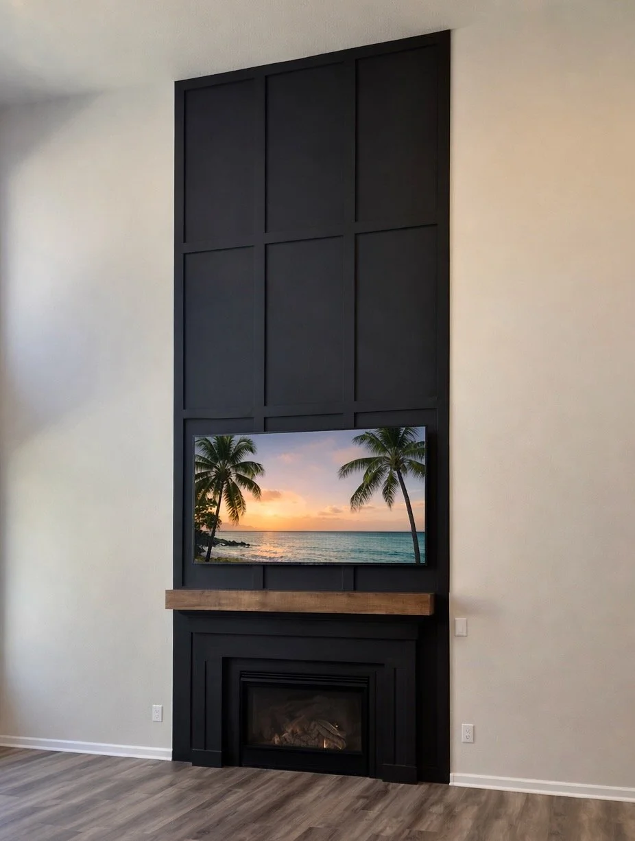 Modern living room with white walls, dark wood wall panel framing a flat-screen TV displaying a beach sunset scene, a wooden mantel above a black fireplace, and light brown hardwood flooring.